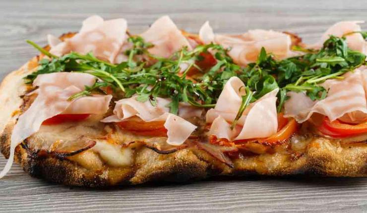 pinsa con prosciutto pomodoro ed erbe aromatiche