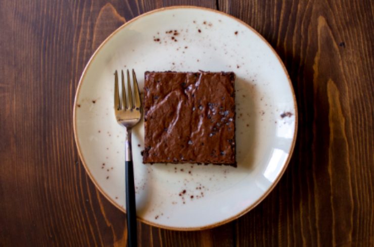 un broniews al cioccolato su un piatto con accanto una forchetta