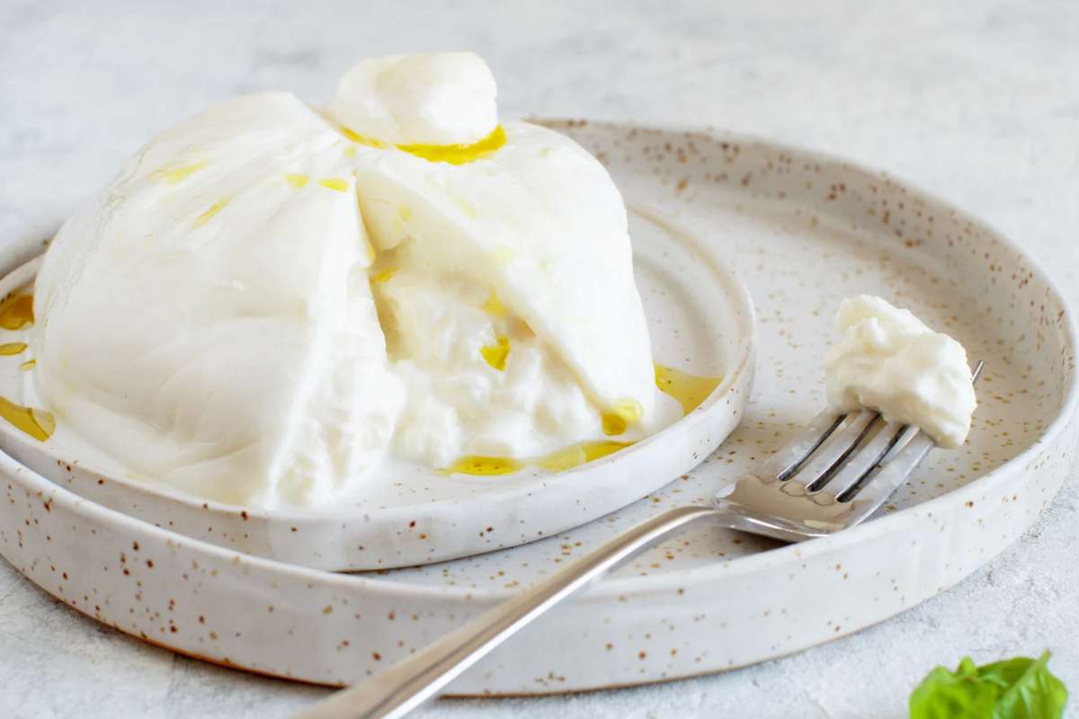 Burrata in un vassoio con forchetta accanto