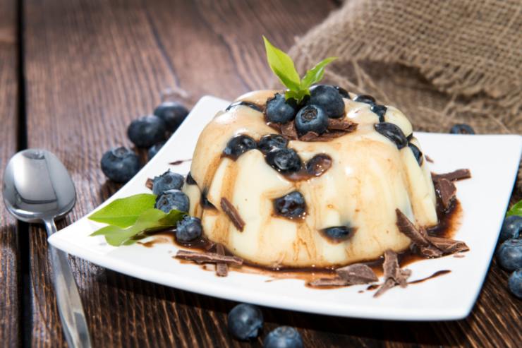 budino ai mirtilli su un piatto con accanto un cucchiaino