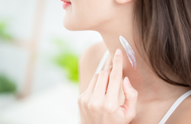 donna che mette la crema sul collo
