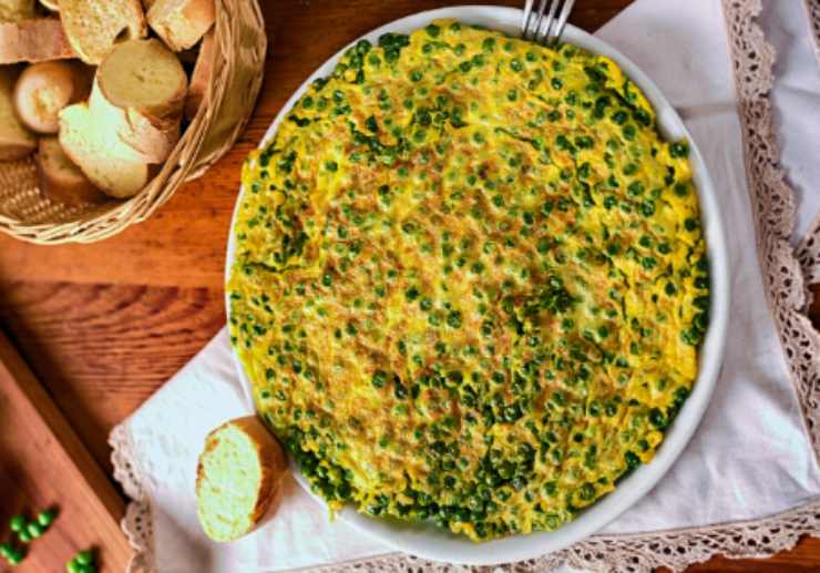 farifrittata di zucchine e piselli con accanto un cestino di pane