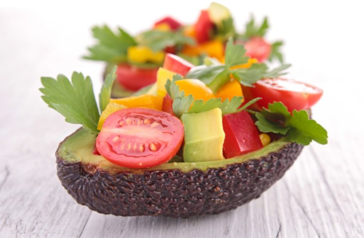 insalata di avocado con melone e pomodori e prezzemolo dentro ad un mezzo avocado