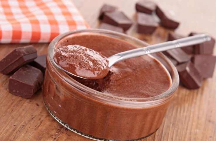 mousse al cioccolato dentro ad un bicchierino di vetro e sopra un cucchiaino 