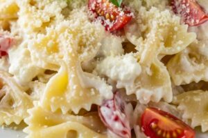farfalle di pasta cremose con pomodori