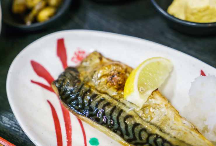 uno sgombro grigliato nel piatto con il limone