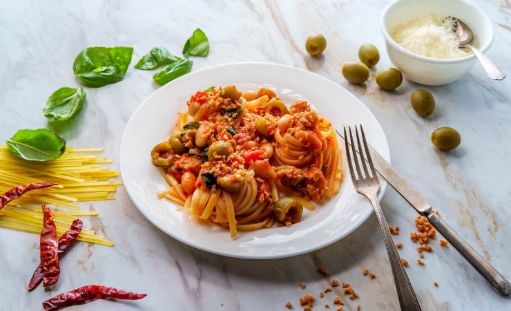 piatto di pasta al pomodoro e olive verdi