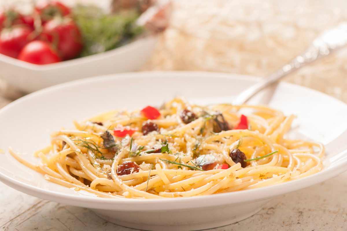 Piatto di spaghetti con pomodorini, capperi e prezzemolo