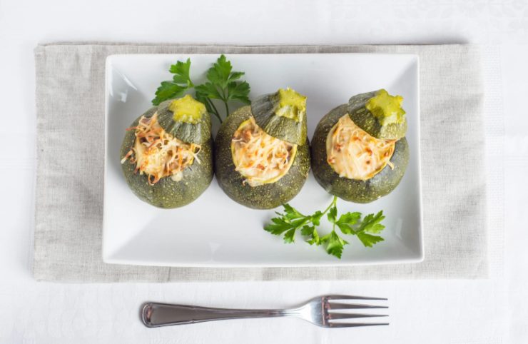 tre zucchine tonde ripiene su un piatto