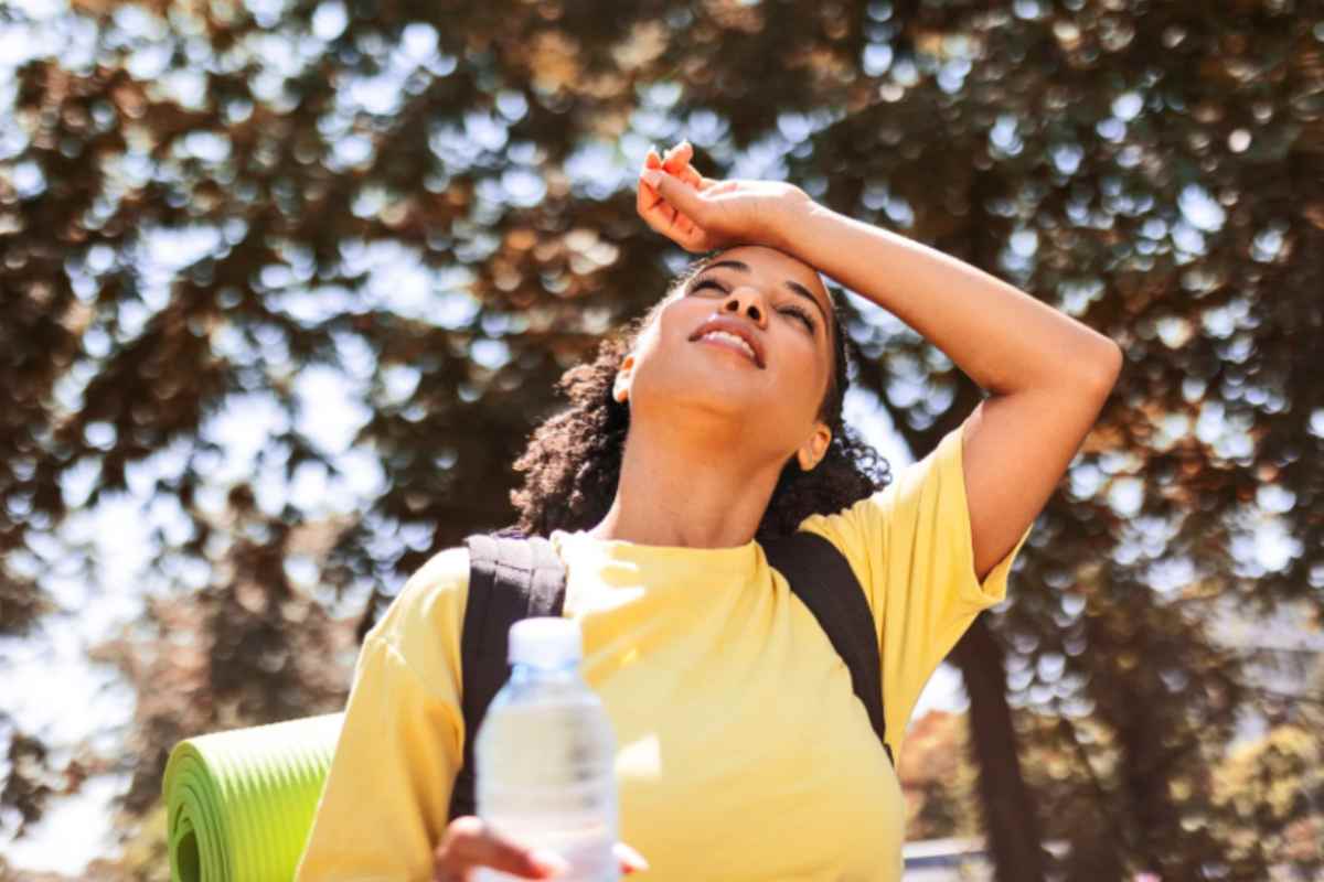 donna che ha caldo con una mano sulla fronte