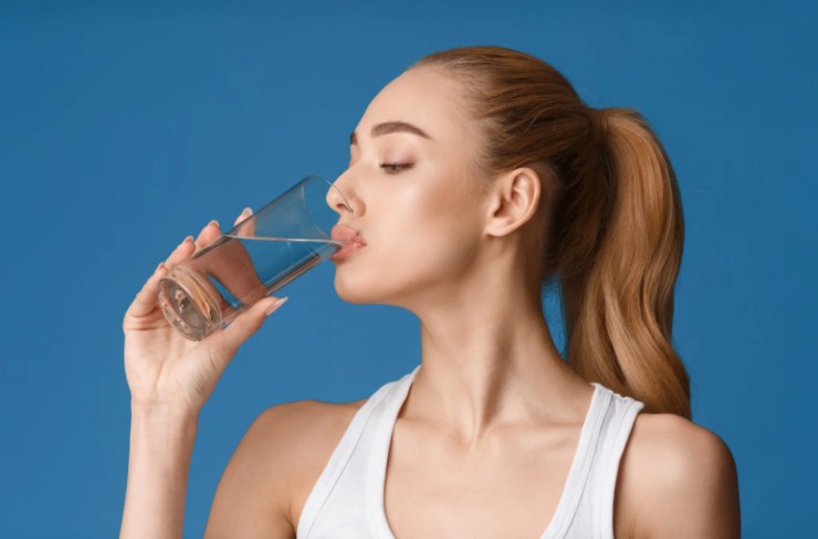 donna che beve un bicchiere di acqua