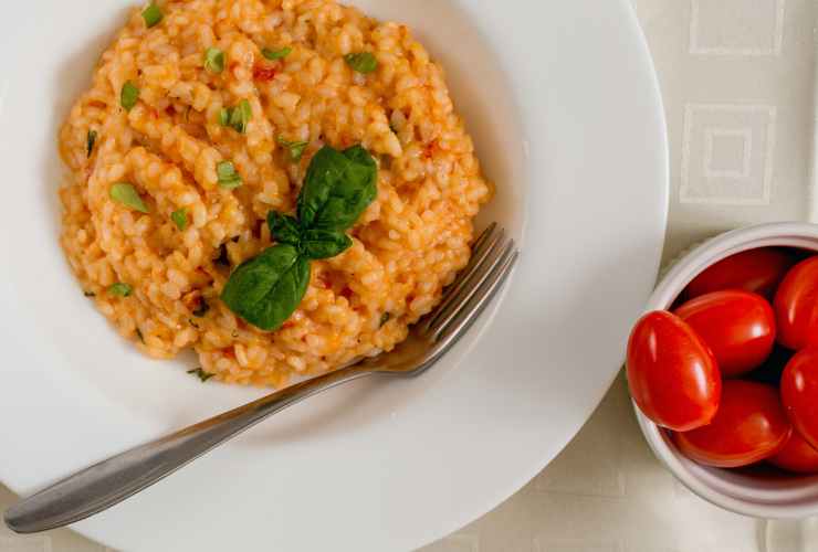 piatto con risotto al pomodoro e pomodorini accanto