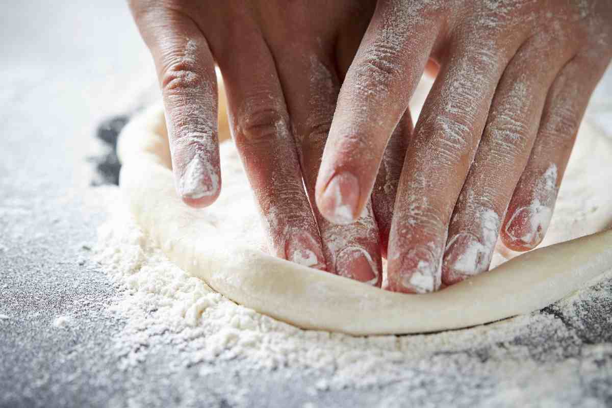 persona stende impasto della pizza