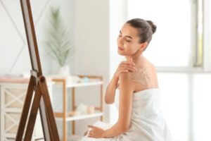 donna che si applica lo scrub sulla schiena