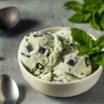 Ciotola con gelato alla menta, foglie di menta e scaglie di cioccolato