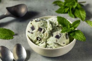 Ciotola con gelato alla menta, foglie di menta e scaglie di cioccolato