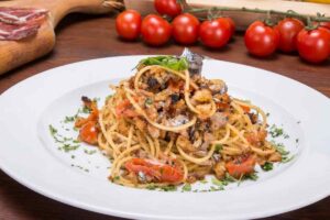 Piatto di spaghetti con pomodoro, prezzemolo e acciughe