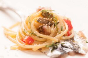 Porzione di spaghetti con pomodorini, capperi e pesce spada