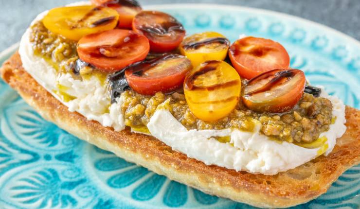 Bruschetta con burrata e pomodorini divisi a metà