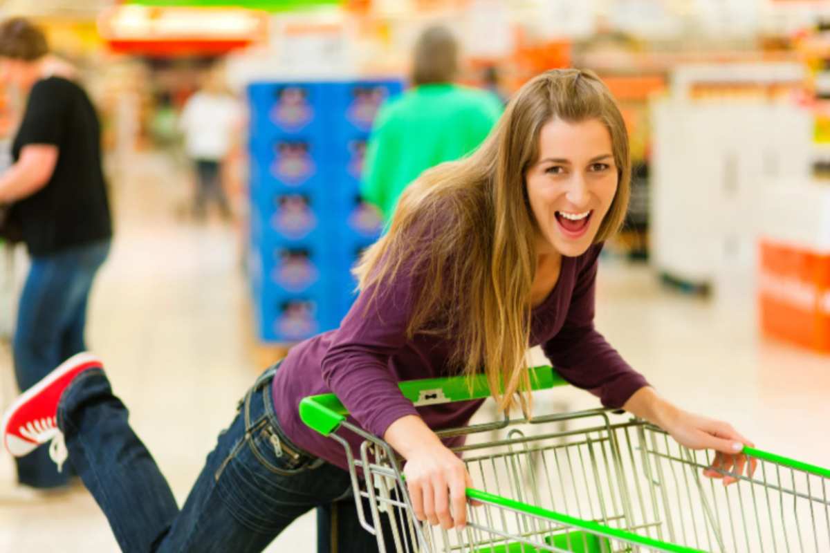 donna che corre con il carrello della spesa