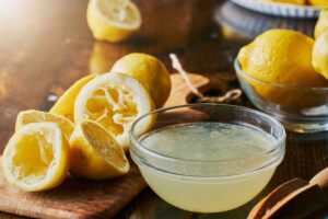 ciotola con succo di limone e limoni sul tavolo