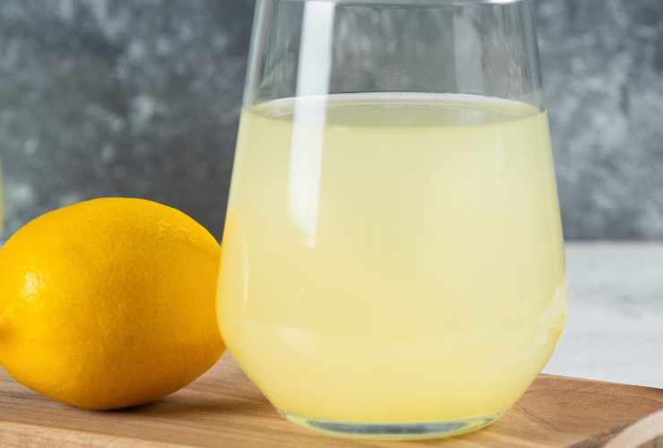 bicchiere con succo di limone e un limone intero