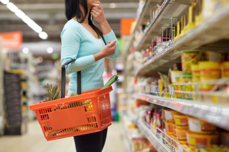 donna al supermercato con il cestino attaccato al braccio