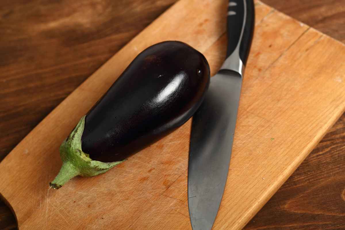 Melanzana su un tagliere con coltello vicino