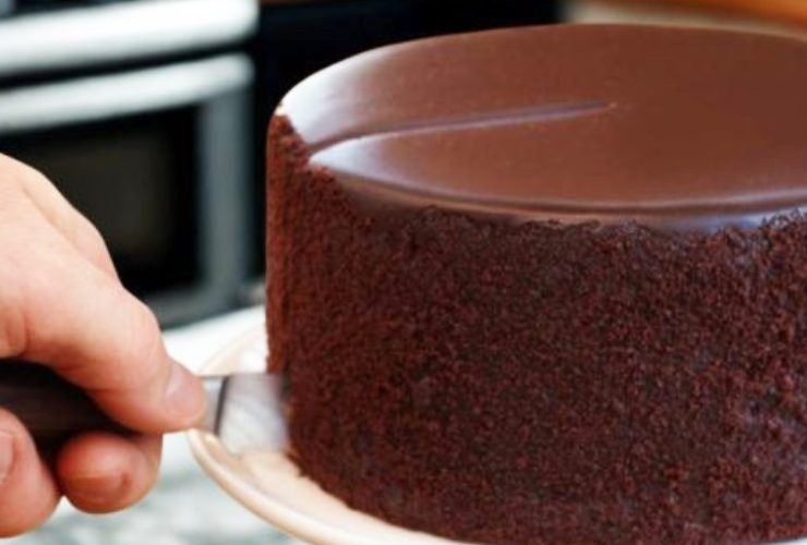 persona che taglia una fetta di torta al cioccolato