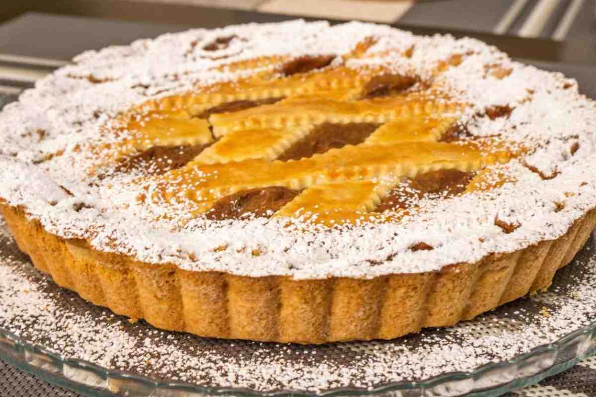 crostata intera con zucchero a velo in un vassoio