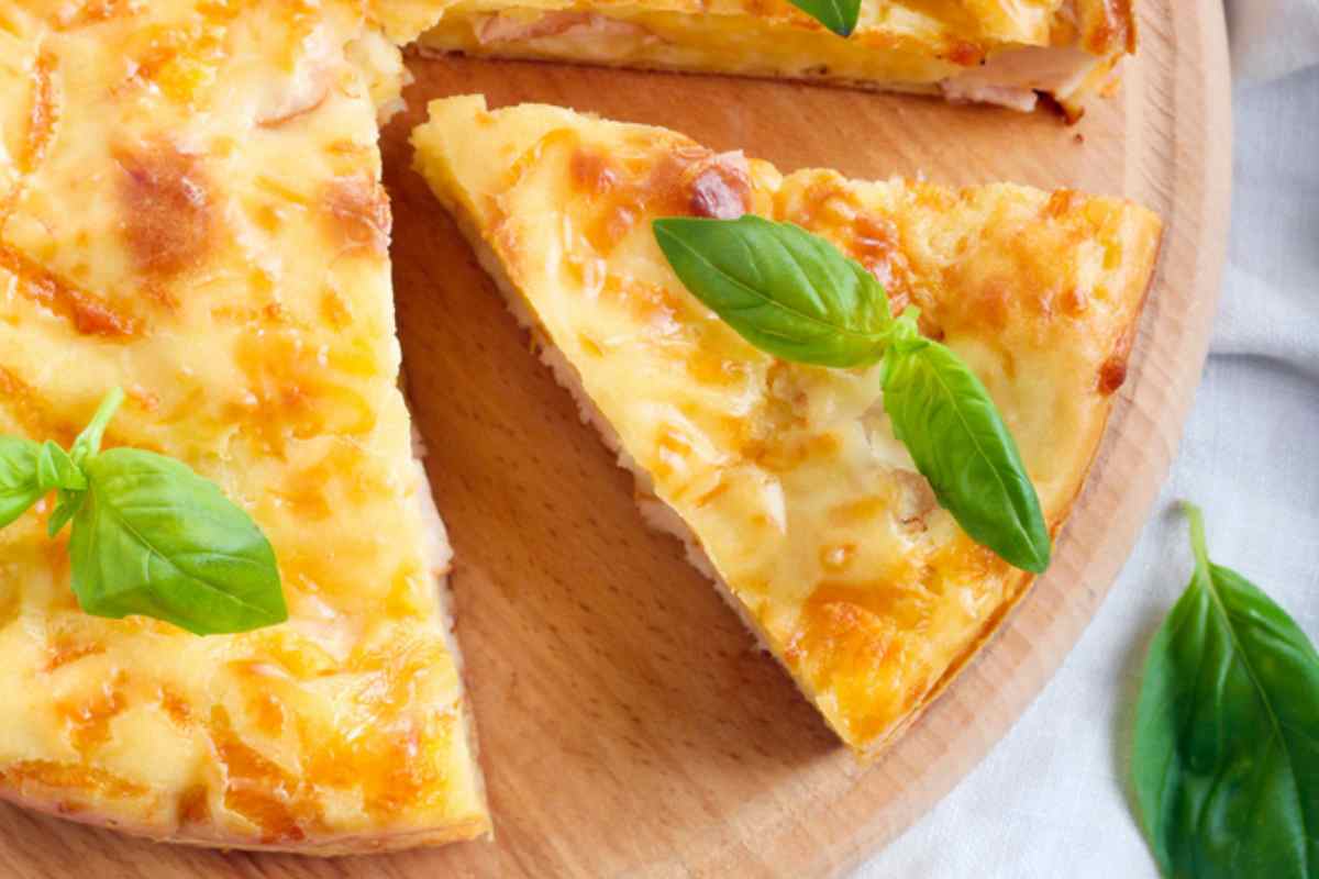 Torta rustica tagliata con foglie di basilico