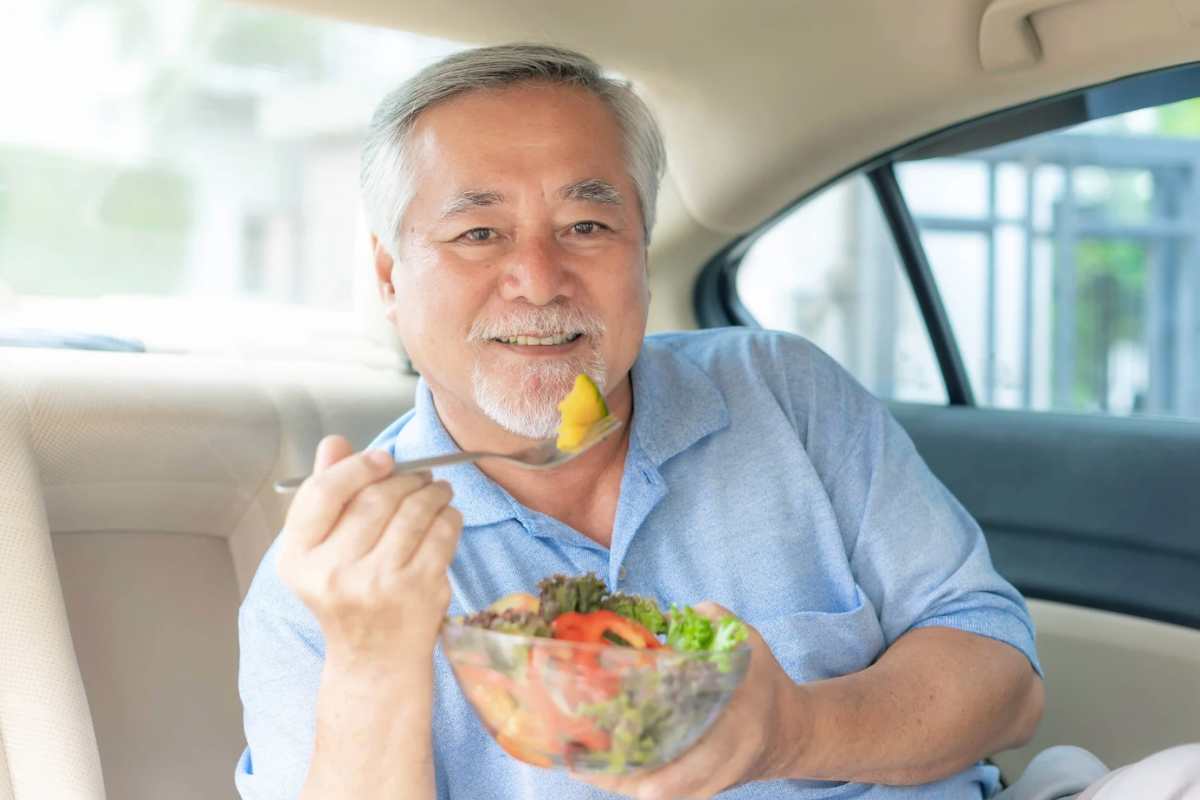 Uomo che mangia insalata in macchina