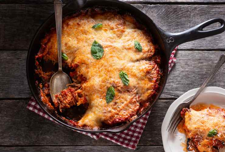 padella con zucchine, pomodoro e mozzarella e piatto con un pezzo tagliato