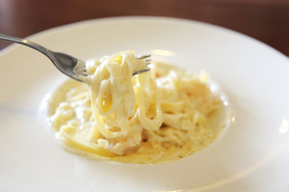 Spaghetti cremosi in un piatto conditi con besciamella