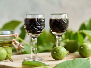 liquore alle noci dentro bicchierini con malli intorno
