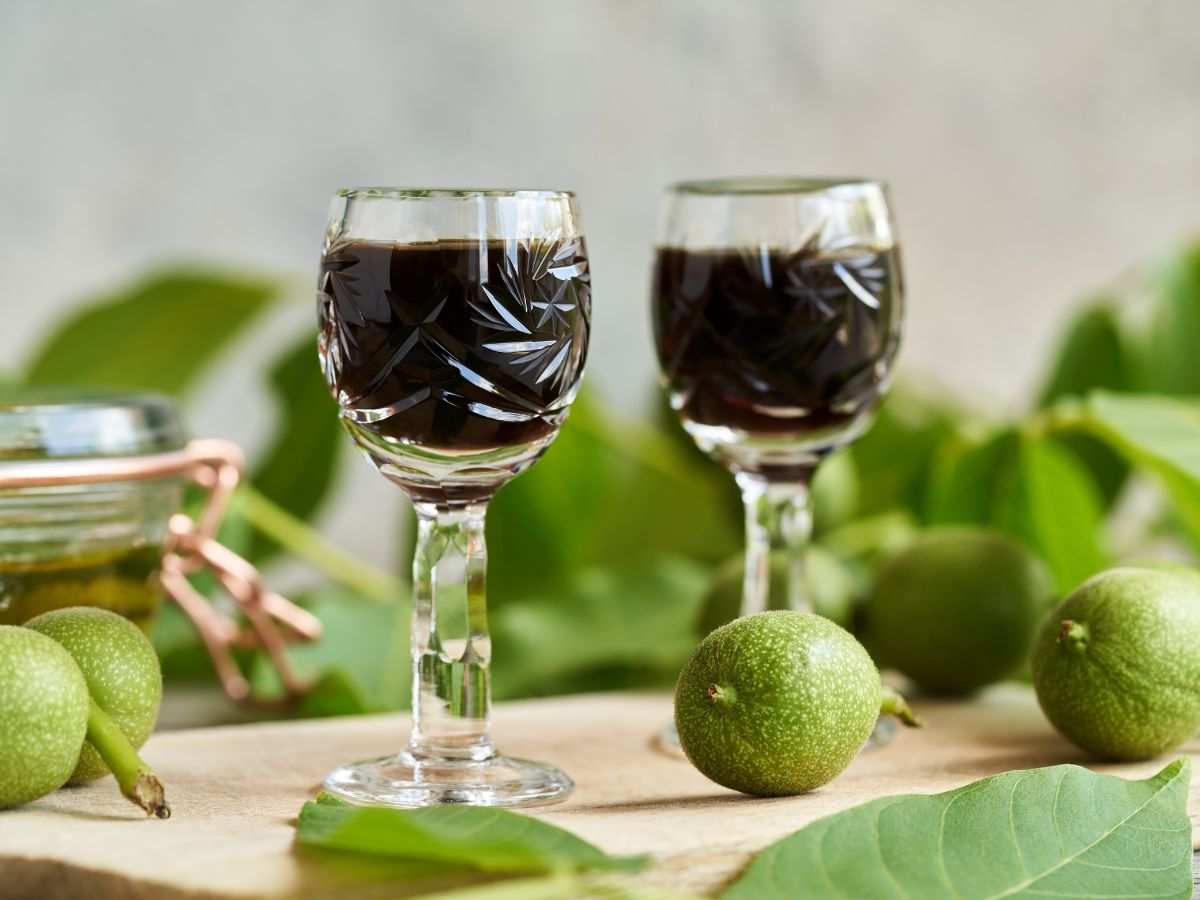 liquore alle noci dentro bicchierini con malli intorno