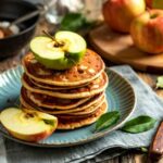 dei pancakes impilati con fette di mela in superficie