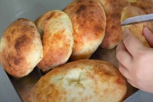 pane turco e mano che lo taglia con un coltello