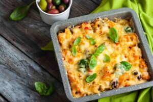 pasta al forno con formaggio filante olive e foglie di basilico fresco