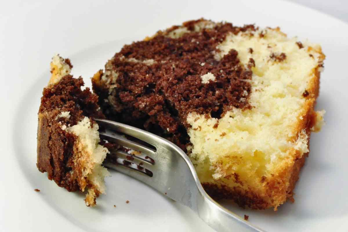 Fetta di ciambella bicolore nel piatto con forchetta