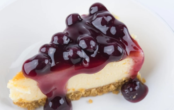 fetta di cheesecake ai mirtilli sopra ad un piatto